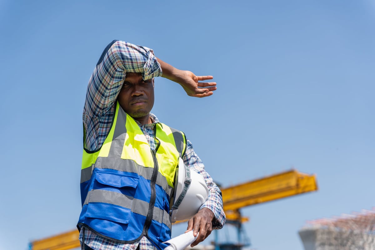 SpillGuard construction worker shielding his eyes on a coastal response site
