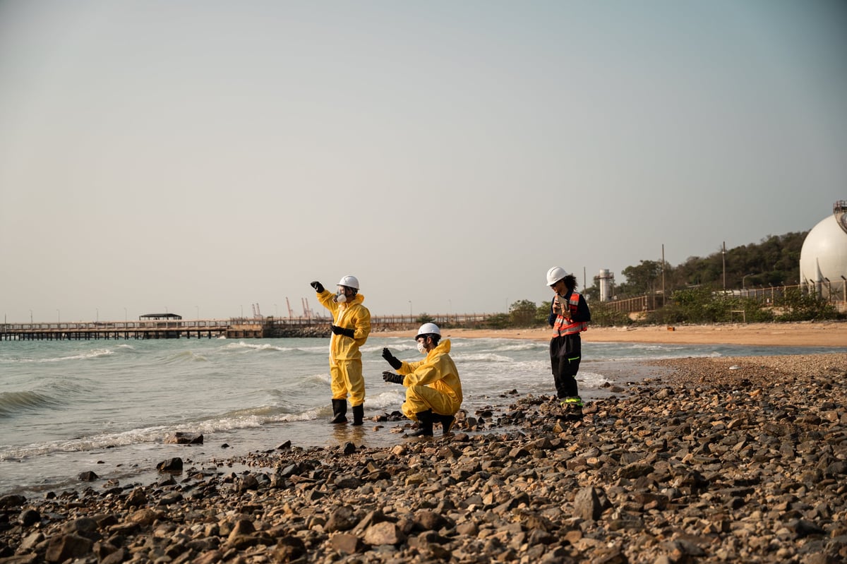 Ghanaian engineering workers with tablets inspecting a coastal industrial site